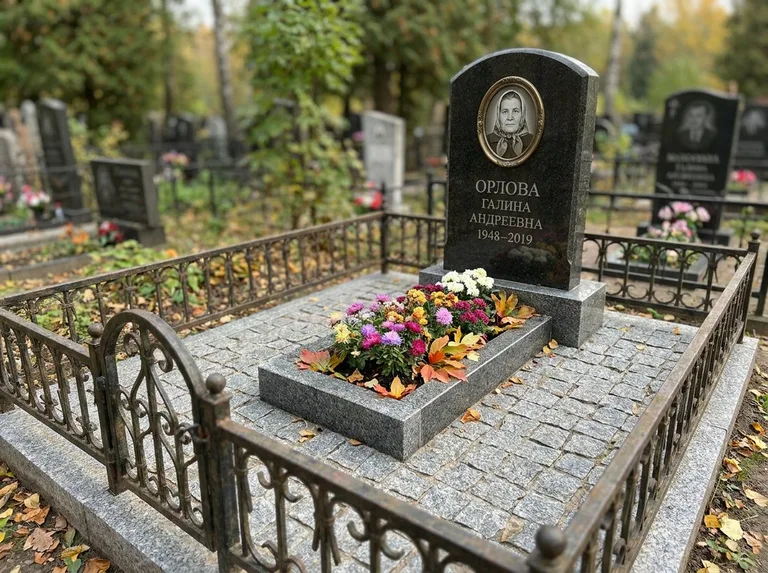 Благоустроенное захоронение с гранитной плиткой, оградой и цветником в Магнитогорске