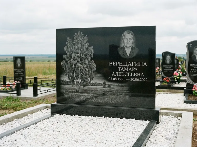 Памятник с гравировкой берёзы: широкая горизонтальная стела — берёза у поля, простор до горизонта, белая мраморная крошка с бордюром, работа «Верещагина» в Магнитогорске