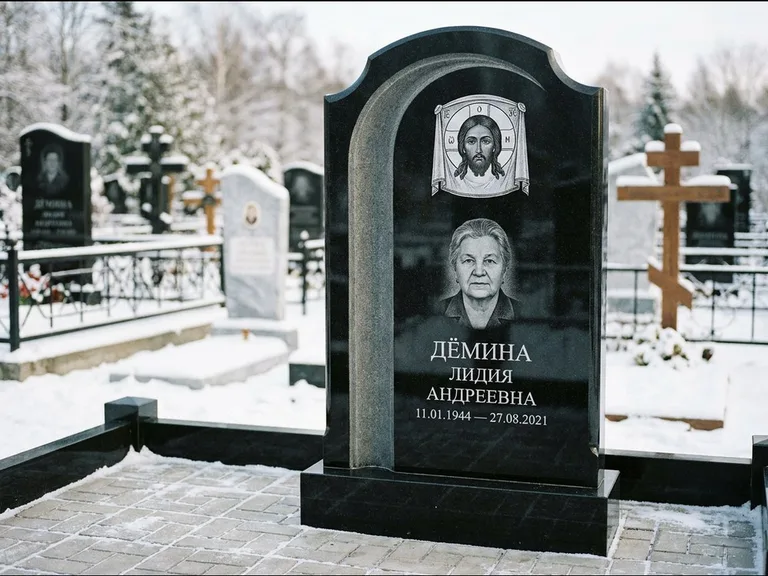 Памятник с гравировкой иконы: гранёный восьмиугольный обелиск с крестом — гравировка Николая Чудотворца, семейный участок с гранитной скамьёй, работа «Зотов» в Магнитогорске