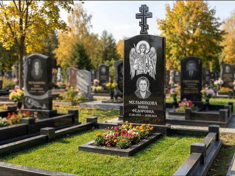 Памятник с гравировкой иконы: округлая стела-медальон с ликом — гравировка Богородицы «Семистрельная», луговые травы и полевые цветы за участком, работа «Гущин» в Магнитогорске
