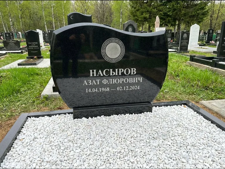 Мусульманский памятник: стела с волнообразным скошенным верхом — гравировка мечети под полумесяцем и звёздами, белая мраморная крошка с бордюром, работа «Насыров» в Магнитогорске