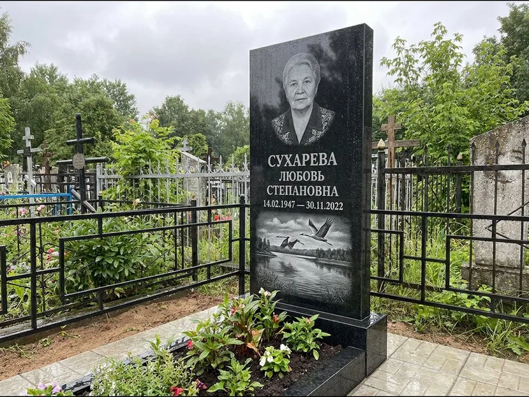 Памятник с гравировкой журавлей — гравировка пары журавлей над гладью озера в нижней части, работа «Сухарева» в Магнитогорске