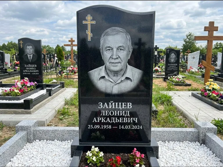 Памятник из чёрного гранита — горизонтальная семейная стела с аркой с процветшим крестом с виноградной лозой, работа «Верещагин» в Магнитогорске