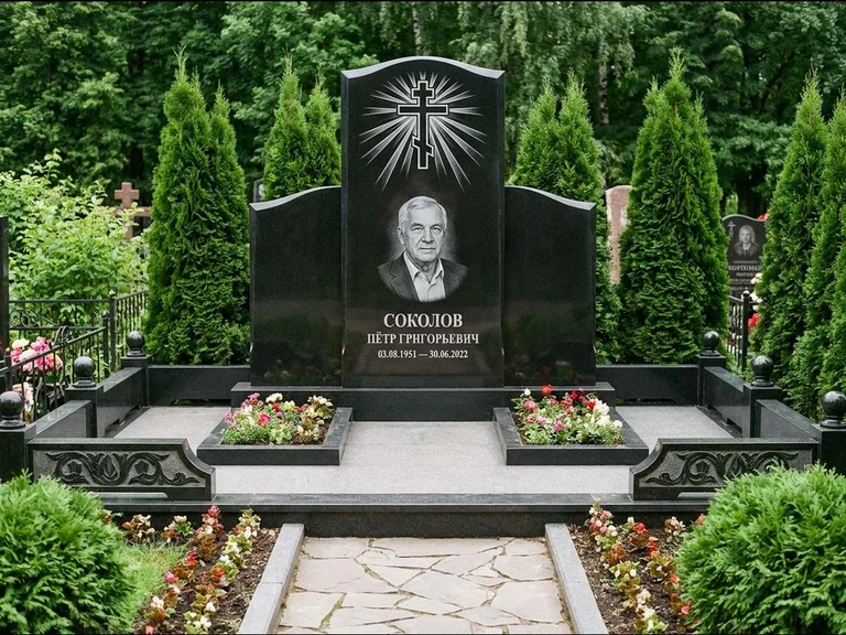 Памятник из чёрного гранита — низкая стела с крестом сбоку с золочёным крестом, работа «Верещагин» в Магнитогорске