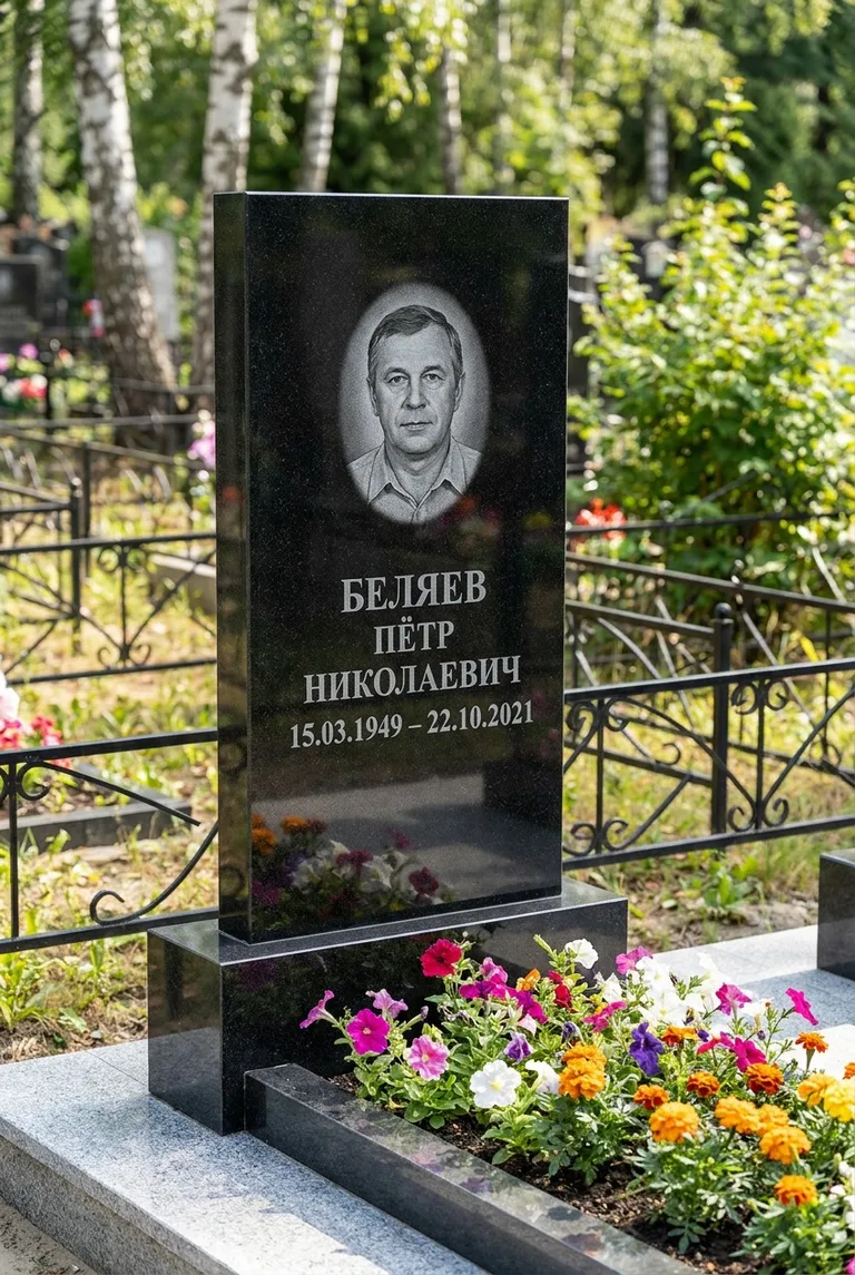 Вертикальный чёрный гранитный памятник под ключ с цветником в Магнитогорске