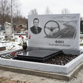 Гранитный памятник дальнобойщику с уходящей вдаль дорогой